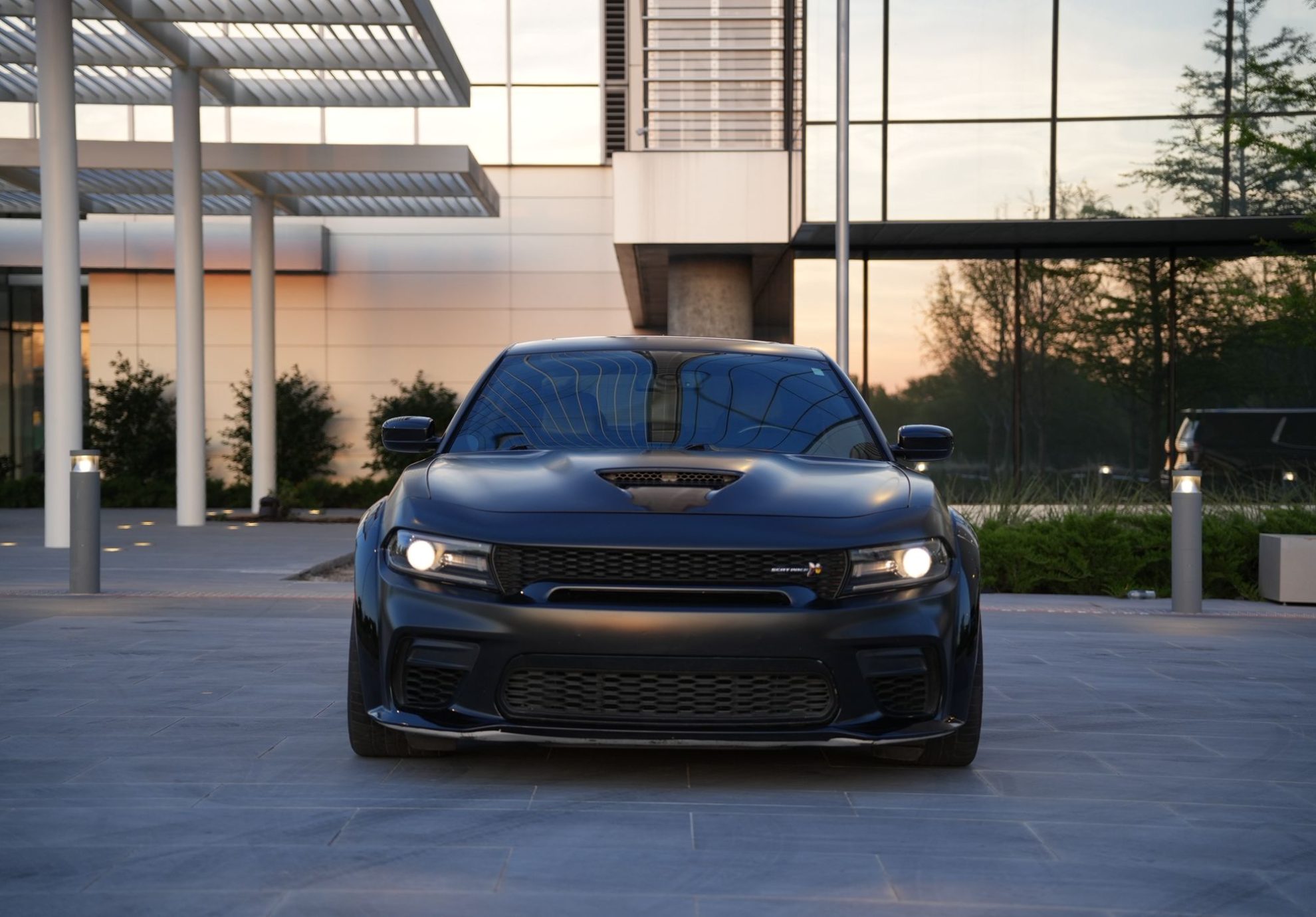 Side view of Dodge Charger Scat Pack Rental in Dallas with matte black finish, wide body, and sporty design
